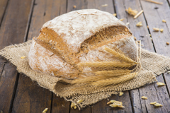 Hogaza de pan de trigo y centeno sobre una arpillera en la mesa